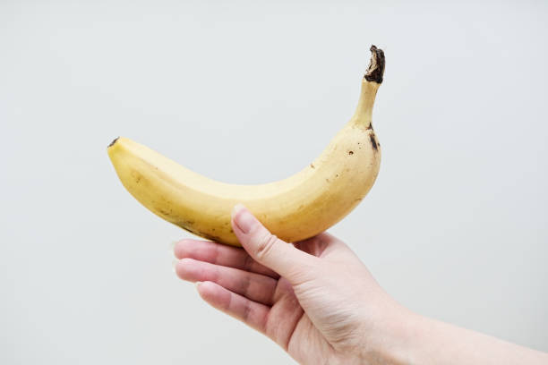 istock Woman's hand holding banana fruit. 2155055065