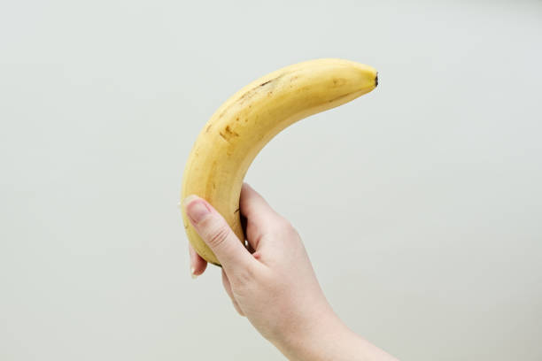 istock Woman's hand holding banana fruit. 2155055069