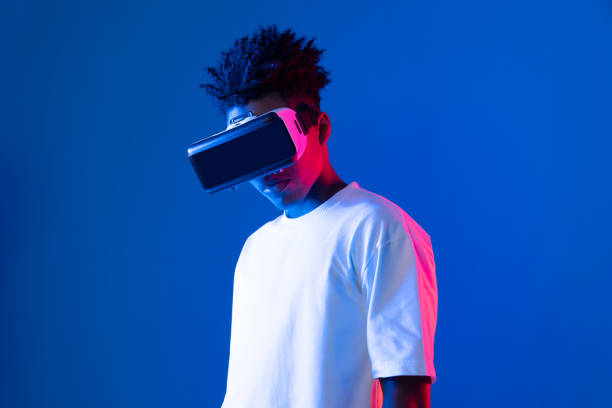 istock Surprised African looking VR holding object hologram neon wall. Contrivance. 2155055269