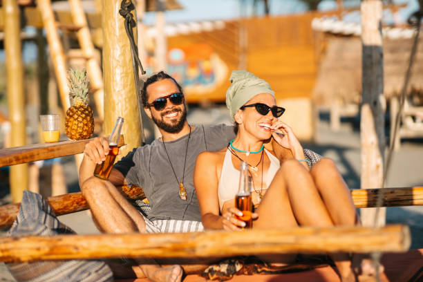 istock Couple drinking beer at beach 2155056357