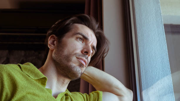 istock Dreamy man is looking through the window 2155058219