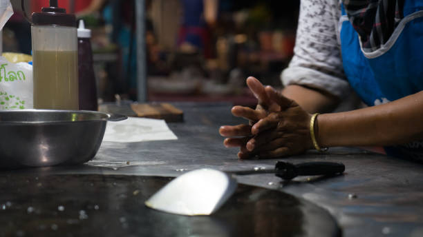 a person show hands cooking at food street