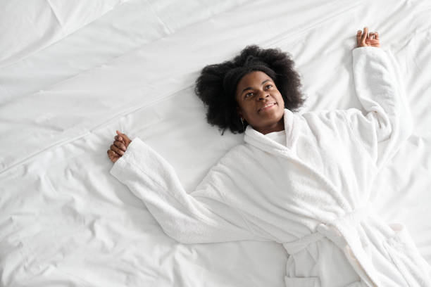 istock Young woman lying on fresh white bed 2155061821