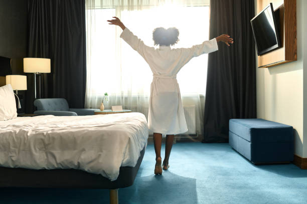 Woman dancing in bedroom with sunlight