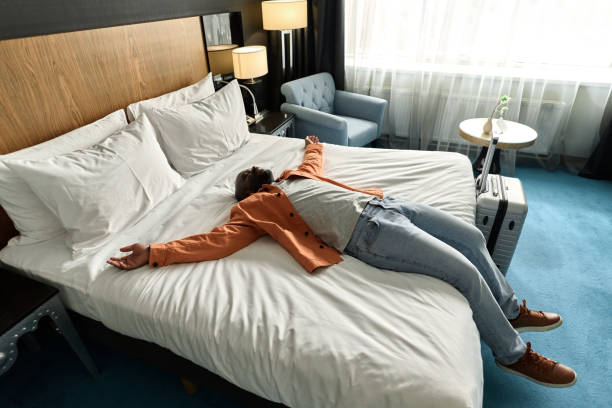 Man Lying on Bed in Hotel