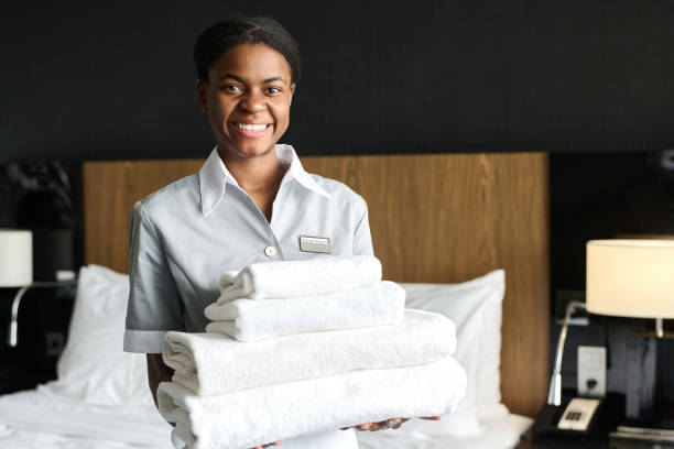 istock Young Housekeeper Holding Stack of Fresh Bedding 2155061953