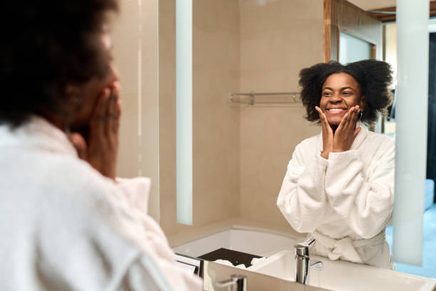 istock Smiling Black woman looking in mirror 2155061969