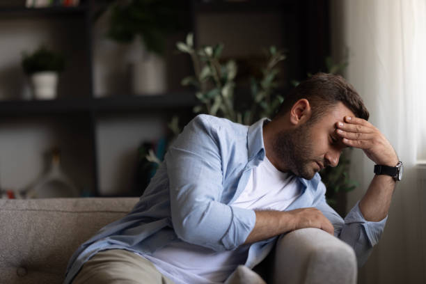 istock Man alone at home looking sad and distraught 2155063031