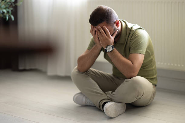 istock Man alone at home looking sad and distraught 2155063140
