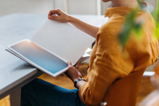 istock Person Reading A Book at a Table in a Cozy Room 2155064690