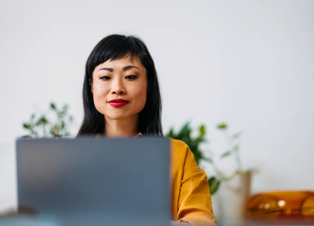 istock Focused Woman Working on Laptop in Home Office Setting 2155064697
