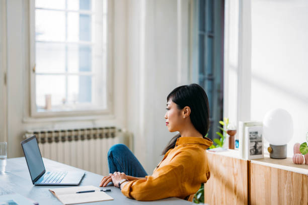 Woman Working Remotely at Home With Laptop and Notes