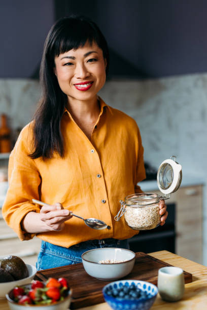 istock Smiling Woman Preparing Healthy Breakfast in Modern Kitchen 2155064848