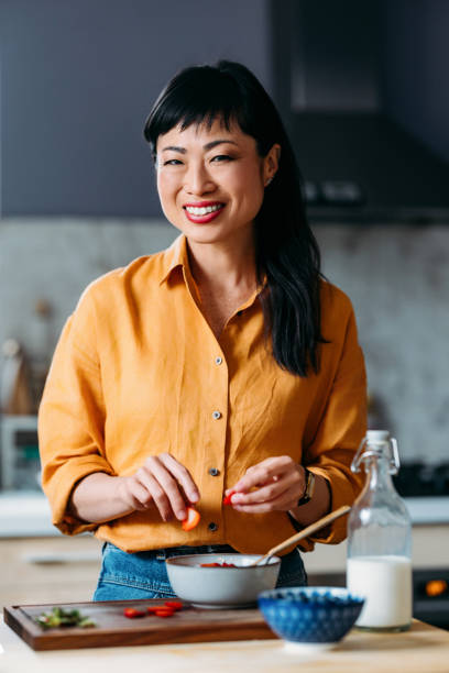 istock Happy Woman Preparing Meal in a Modern Kitchen 2155064862