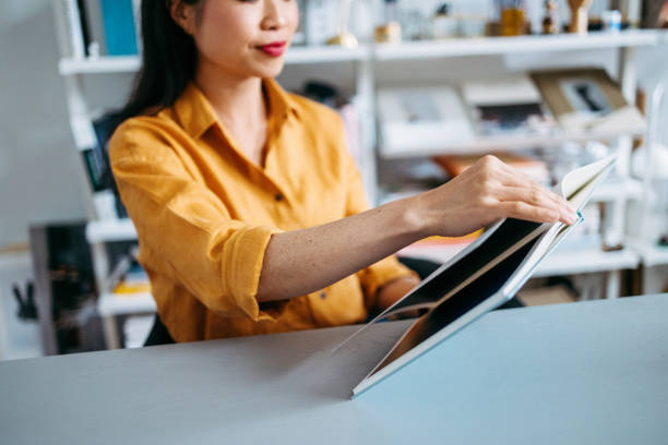 Focused woman reading a magazine in a modern, well-organized office space, highlighting concentration and productivity.