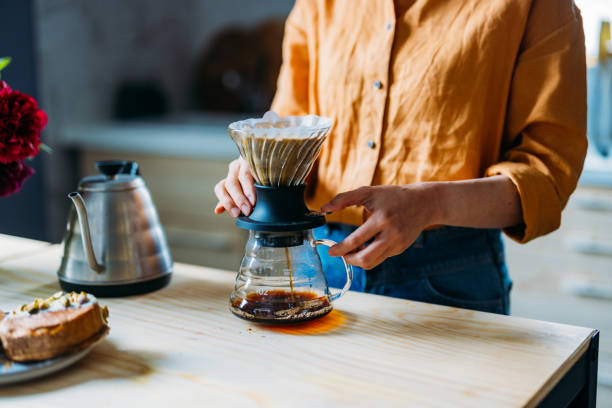 istock Woman Brewing Fresh Coffee Using Pour Over Method in Cozy Kitchen 2155064995