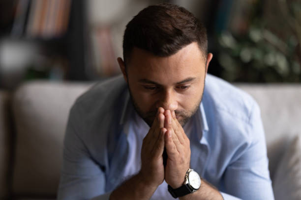 istock Man sitting alone at home looking sad and distraught 2155065784