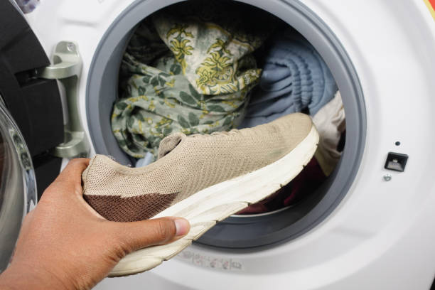 istock putting dirty shoe in a washing machine. 2155066843