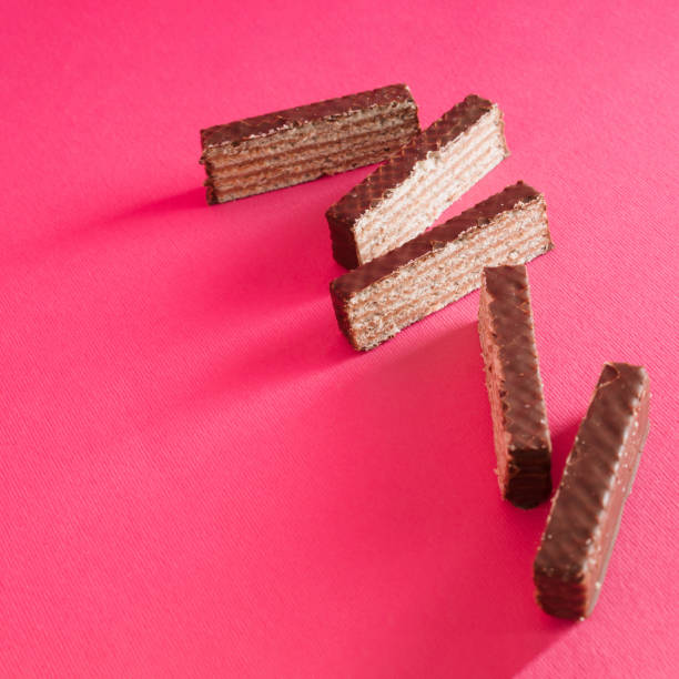 istock Chocolate wafers lined up on an pink background. Copy space 2155069168