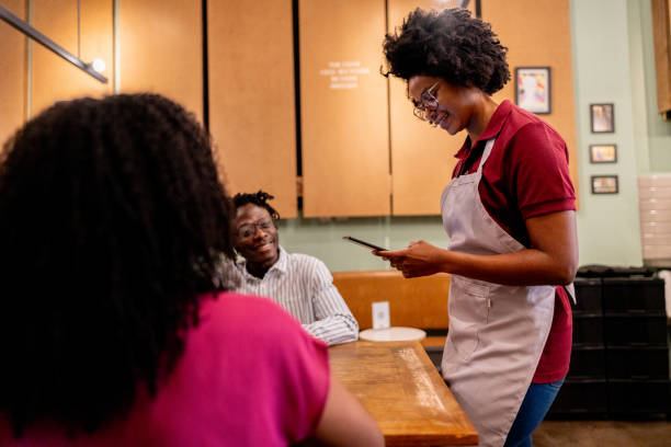 istock Young waitress taking customers'  order on coffee shop 2155074048
