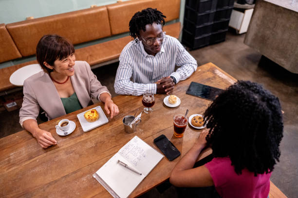 istock Coworkers talking during coffee break at cafeteria 2155074152