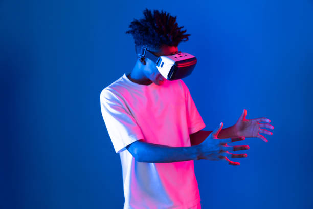 istock Surprised African looking VR holding object hologram neon wall. Contrivance. 2155074988