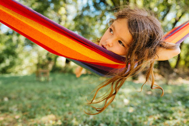 istock Girl resting and daydreaming in a hammock 2155075237