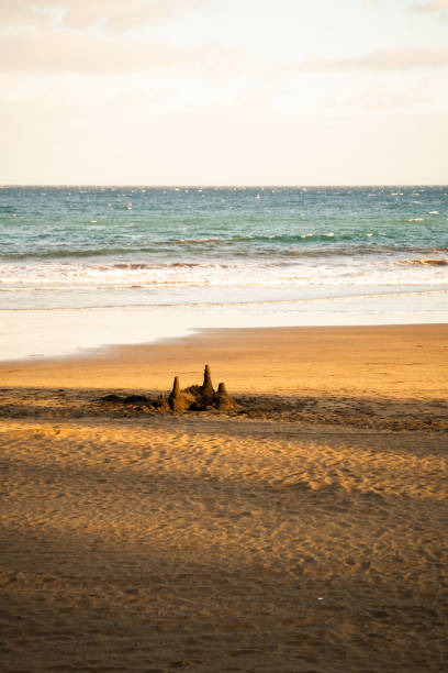 Small Sand Castle on Beach during golden hour, empty frame during day time