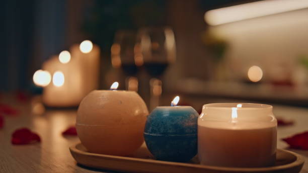 istock Closeup burning candles standing on dark kitchen. Two wine glasses waiting date. 2155076789