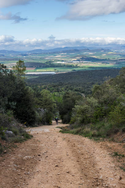 istock Dirt road with large slope and cyclist with bicycle descending. 2155077720