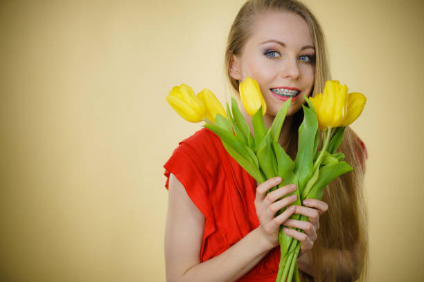 istock Pretty woman with yellow tulips bunch 2155079349
