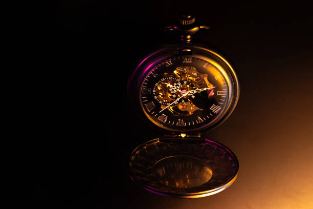 istock Beautiful pocket watch on dark surface with colorful lighting, selective focus. 2155079755