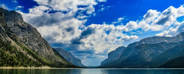 istock Lake Minnewanka Alberta Canada Surrounded by Mountains Under Cloudy Blue Sky 2155080675