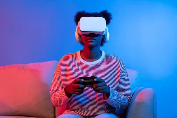istock Smiling African playing gaming player wearing VR control joystick. Contrivance. 2155085905