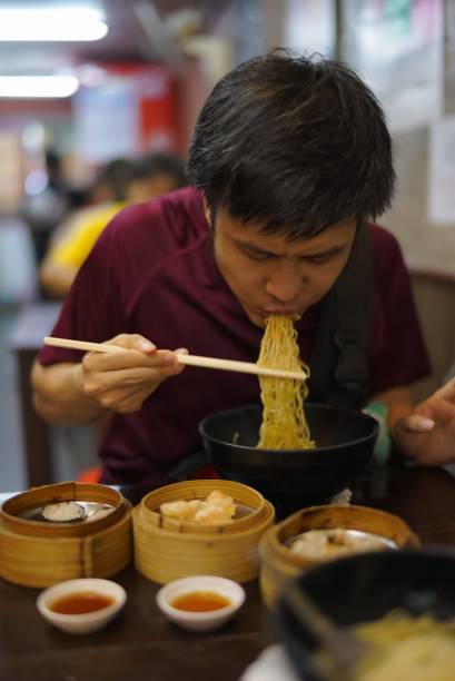 istock Asian man eating noodle with dim sum on the table 2155096595