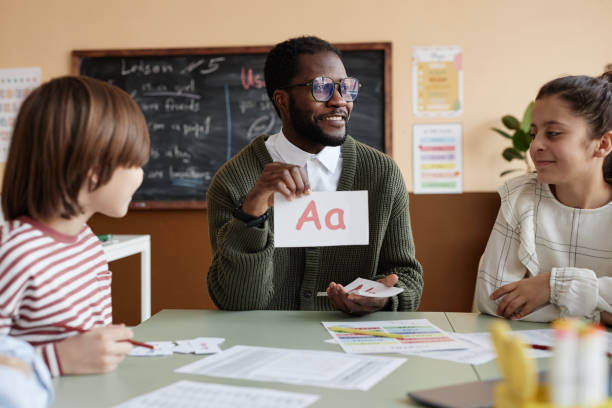 istock Cheerful Black Man Teaching English At School 2155097065