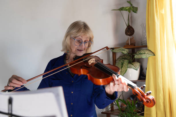 istock mature woman playing violin 2155097627