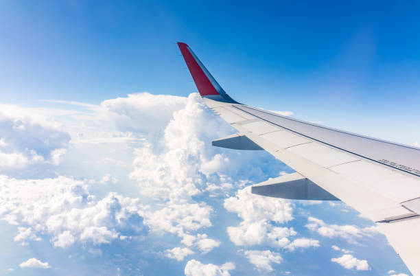 istock View from the airplane window at a beautiful cloudy sky and the airplane wing 2155104552