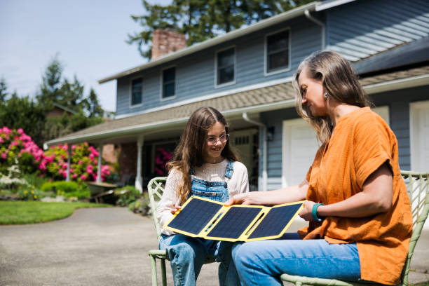 istock Mother Explaining Using Portable Solar Panels to Her Daughter 2155105767
