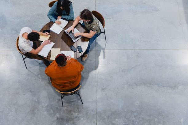 istock Diverse Business Group People Having a Meeting About Sustainable Green Energy, and using Solar Power Source to Charge Phones and Laptops on Table 2155107933