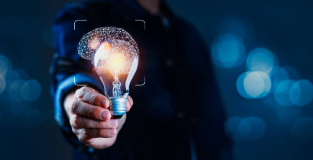 istock A person is holding a light bulb in their hand, with a brain in the background 2155111253