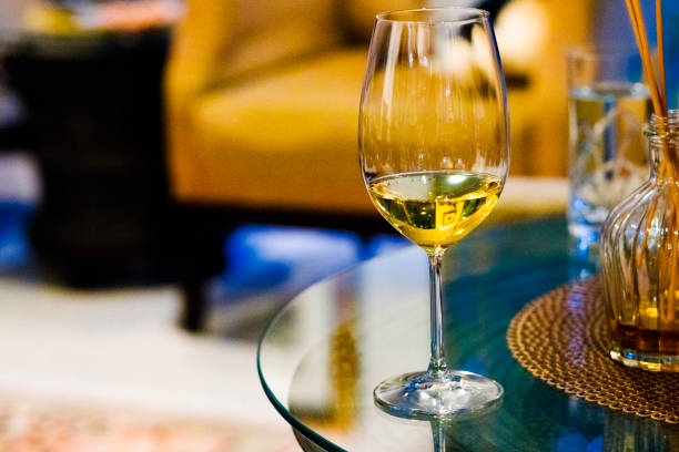 istock Wineglass with white wine  on glassy table 2155111546