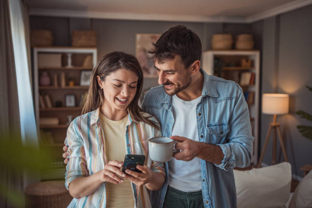 istock Happy couple drinking a cup of coffee at home 2155111940