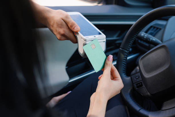 istock a girl makes contactless payment with a smartphone while sitting in a car, 2155112387