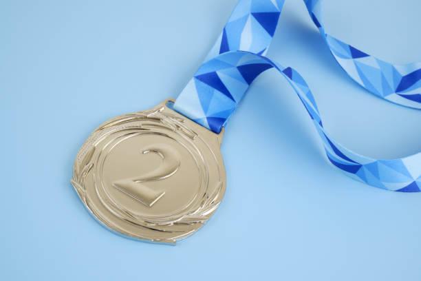 Silver medal with blue ribbon on blue background. Copy space for text.