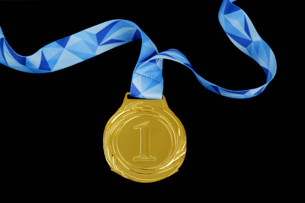 Gold medal with blue ribbon isolated on black background.