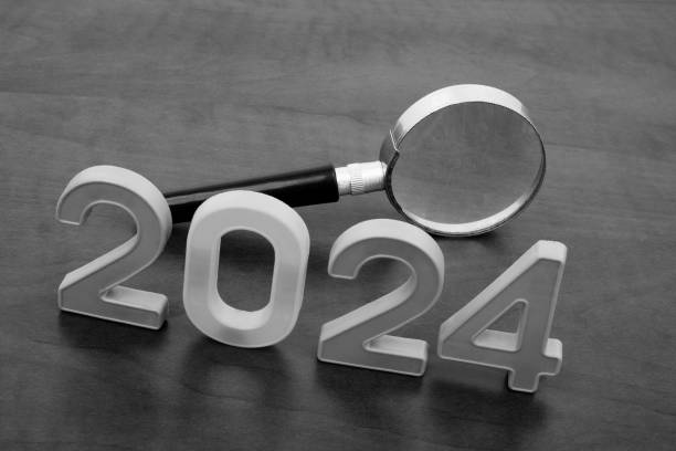 istock Magnifying glass and numbers 2024 on table. 2155114332