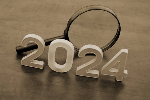 istock Magnifying glass and numbers 2024 on table. 2155114356
