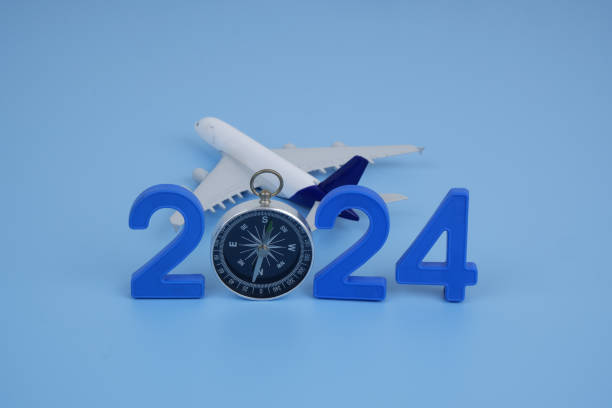 istock Airplane model, compass and numbers 2024 on blue background. 2155114862