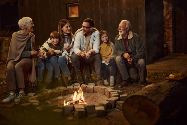 istock Happy extended family talking by the bonfire at night. 2155115969